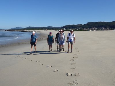 Group of walkers on beach moving towards camera, Algarve, Portugal