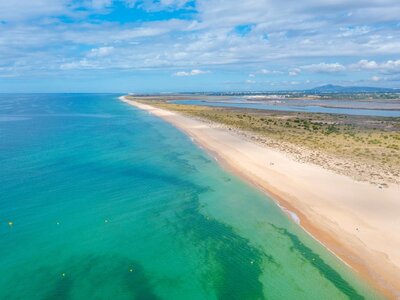 Coastline of turquoise waters and sandy beach of Tavira island, Portugal