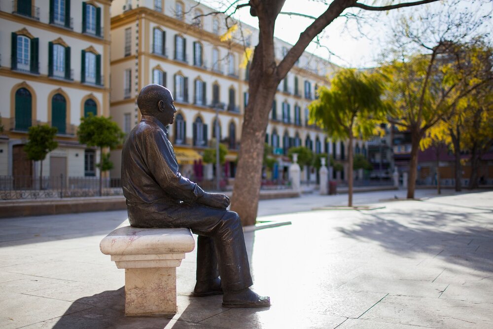 Low side view of Piccasso statue with buildings in background, Malaga, Spain