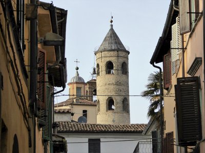 Round bell tower Campanile Cilindrico Città di Castello viewed from street gap between houses, Italy