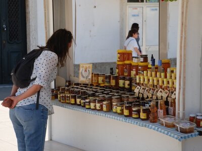 Woman browsing jars at produce market in Vila Real, Portugal
