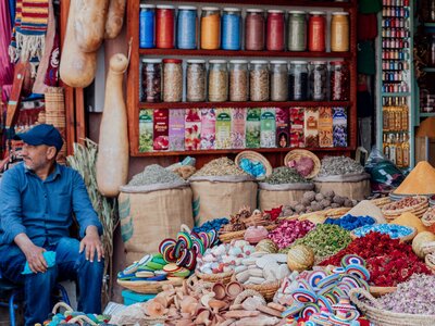 Man selling colourful tea and local supplies in Marrakech, Morocco