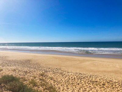 Sandy golden beach with clear blue skies, Tavira island, Portugal