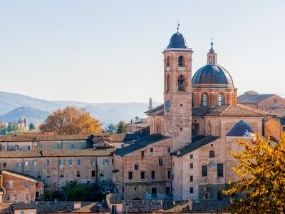 High view of Cathedral of Urbino with hills in background, Urbino, Italy