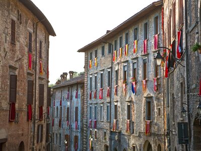 Del Consoli street with flags draped beneath windows, Gubbio, Umbria, Italy
