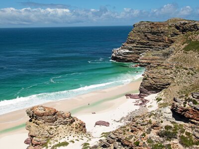 Coastal sea landscape with white waves breaking onto white sand beach in distance, South Africa