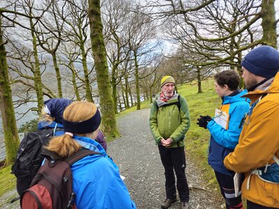 Navigational skills group listening to Ramble Worldwide walking group leader near Buttermere Lake, Lake District, Cumbria