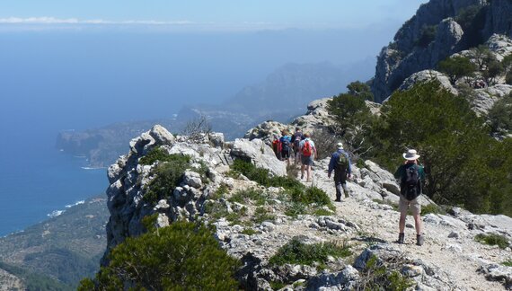 Ramble Worldwide hikers atop mountain with coastal view in distance, Mallorca, Spain