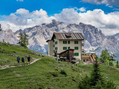 A mountain lodge hotel in the Dolomites, Italy, with walkers approaching